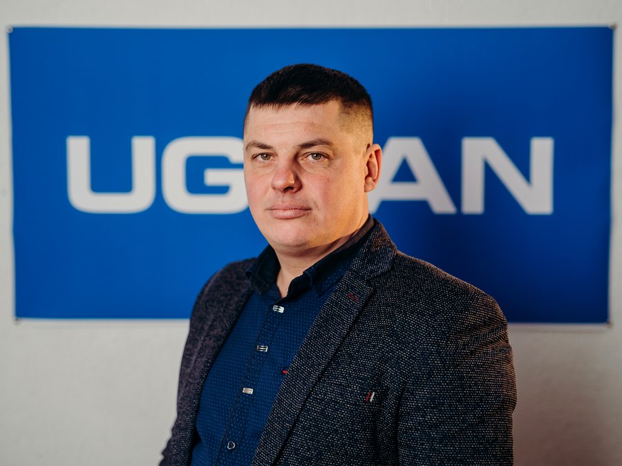 Руководитель направления UGRAN на фоне логотипа